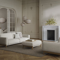 Modern beige sofa set with light gray accents, complemented by a textured brown area rug and subtle wood details.