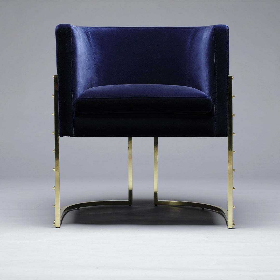 Navy blue velvet chair with sleek gold metal legs, perfect for modern decor. Elegant and stylish design.