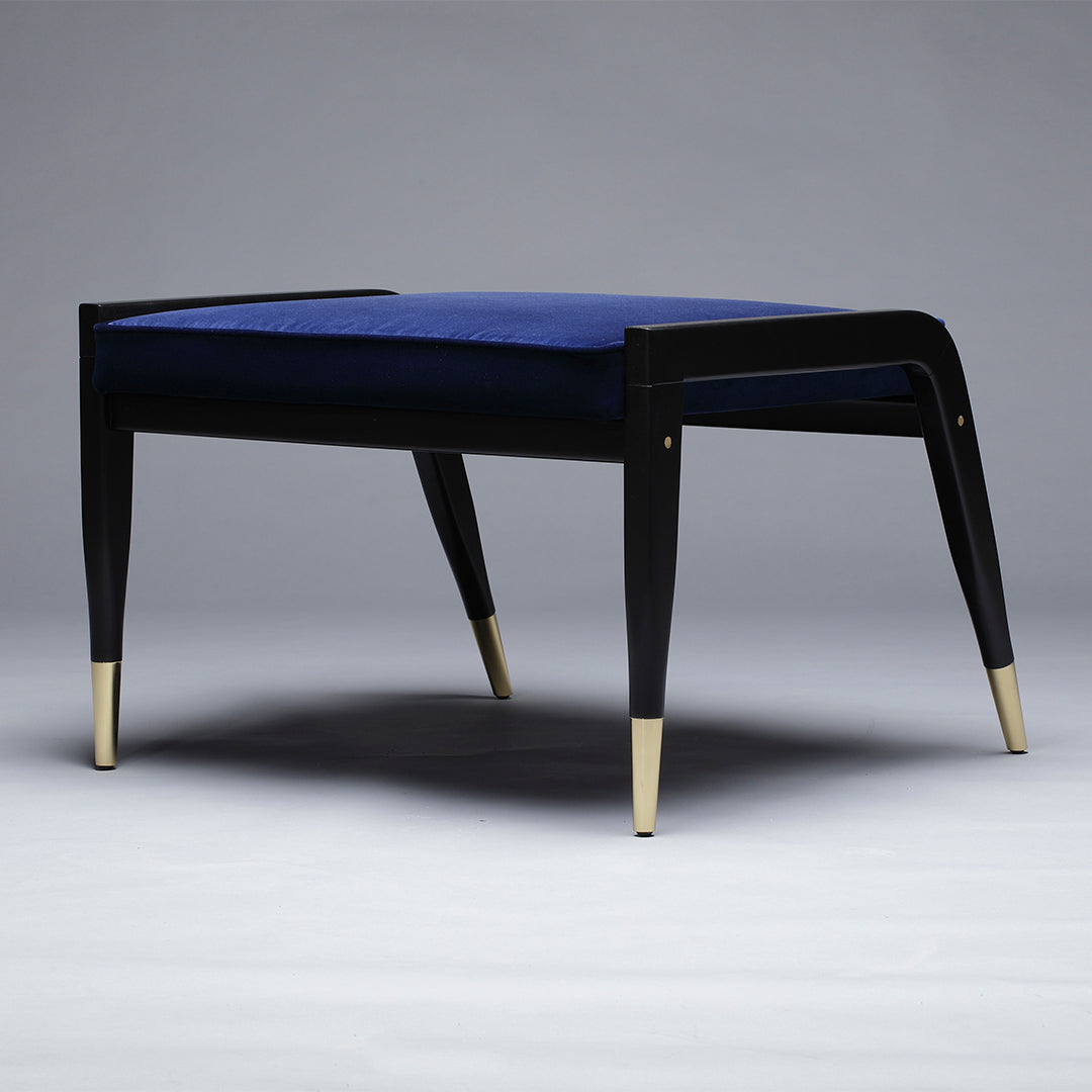 Black and gold accent stool with a plush, deep blue velvet seat, showcasing a modern, elegant design.