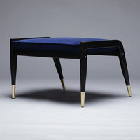 Black and gold accent stool with a plush, deep blue velvet seat, showcasing a modern, elegant design.