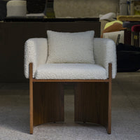 Stylish white boucle armchair with a wooden base, perfect for modern decor. Soft textures and minimalistic design.