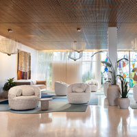 Cozy white round chairs on soft blue rugs with earthy tones and vibrant stained glass accents. Bright and inviting space.