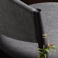 Gray upholstered chair with a sleek black armrest and subtle textured fabric, perfect for modern decor.