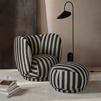 Black and cream striped armchair and ottoman set, featuring bold patterns for a modern aesthetic.