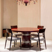Round red dining table with a glossy finish, surrounded by four dark wooden chairs with light gray upholstery.
