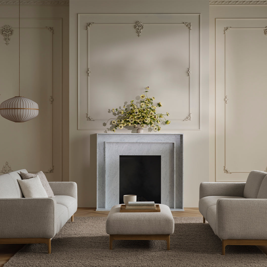 Soft gray sofas with light beige accents and a neutral-toned rug, complemented by a minimalistic white and gray decor.