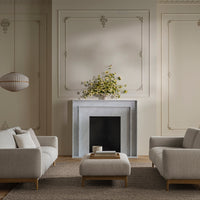 Soft gray sofas with light beige accents and a neutral-toned rug, complemented by a minimalistic white and gray decor.