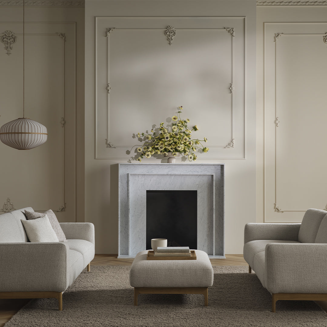 Light gray sofas with beige accents and a textured rug, complemented by soft, neutral wall tones and a modern fireplace.