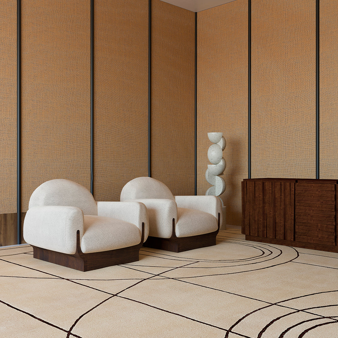 Soft beige chairs with dark wood accents on a light rug featuring abstract brown swirl patterns against warm beige walls.