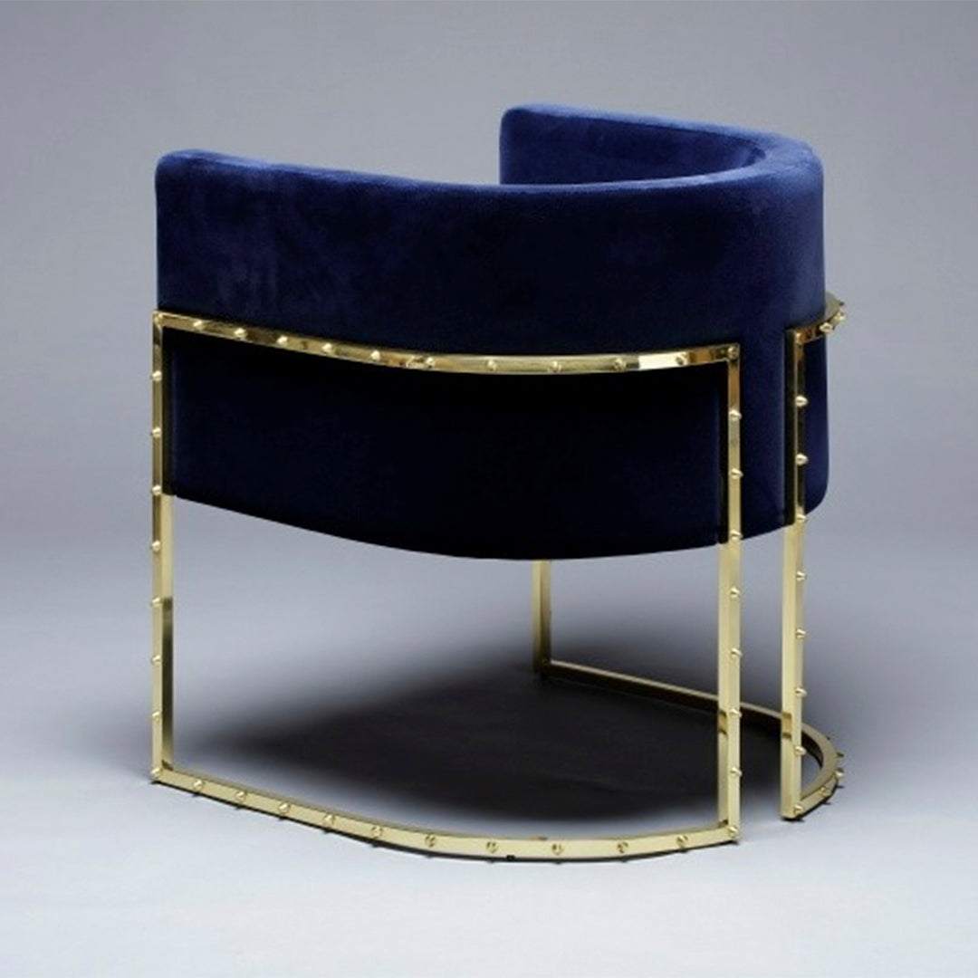 Navy blue velvet chair with a sleek gold metal frame, featuring a modern curved design.