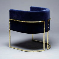 Navy blue velvet chair with a sleek gold metal frame, featuring a modern curved design.
