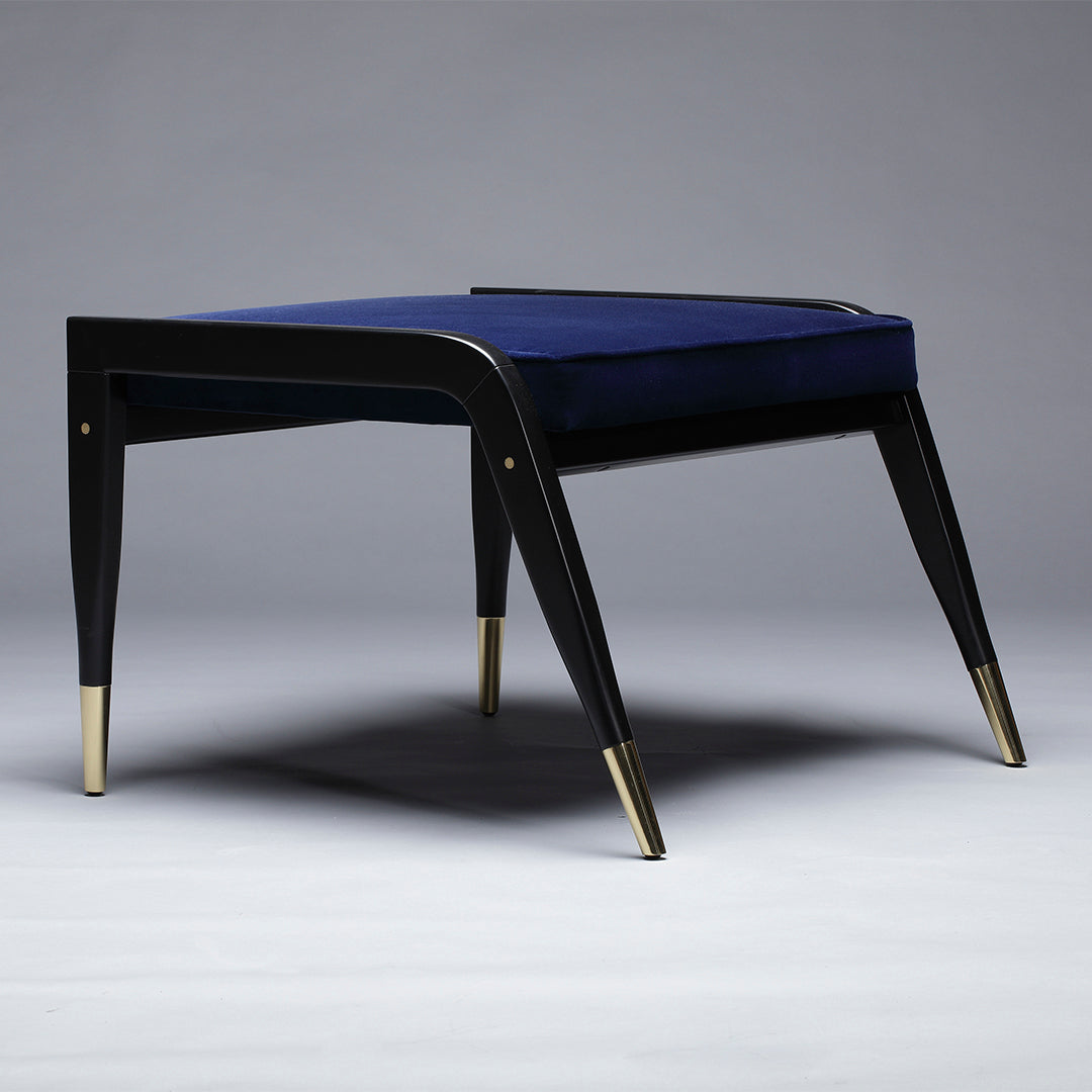 Navy blue velvet upholstered stool with sleek black legs and gold accents, featuring a modern, minimalist design.
