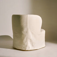 Cream-colored upholstered chair with a smooth, minimalist design and subtle texture. Perfect for modern decor.
