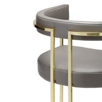 Gray faux leather bar stool with a sleek gold metal frame and minimalist design. Perfect for modern decor.