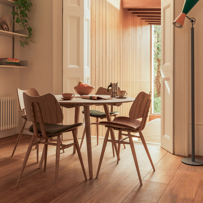 "Modern dining set featuring natural wood tones and earthy fabric colors in a light, airy atmosphere."