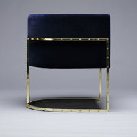 Navy velvet chair with gold metal accents and smooth geometric lines for a modern aesthetic. Perfect for stylish interiors.