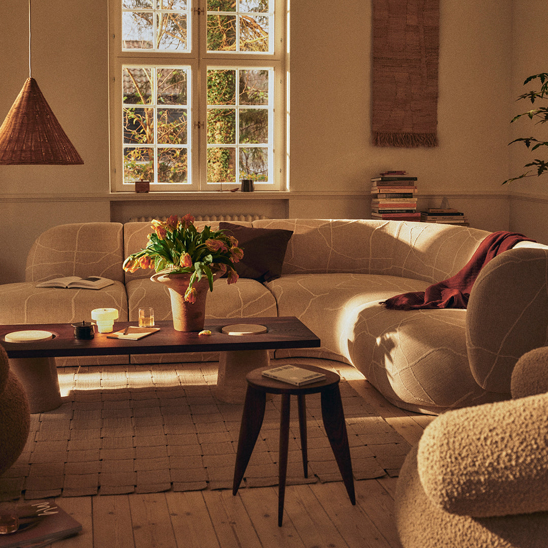 Cozy beige sofa set with textured patterns, warm tones, and natural light creating an inviting atmosphere.