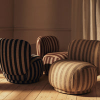 Striped armchairs in earthy tones of black, brown, and cream, featuring bold vertical patterns against wooden flooring.