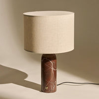 Beige linen lampshade atop a rich brown marble base with white veining, creating an elegant contrast.