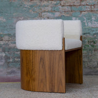 White boucle upholstery with a warm wood base, featuring a smooth, curved design and textured contrast.