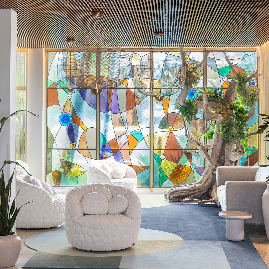 "Vibrant stained glass window with geometric patterns in blue, green, amber, and clear hues, adding color to the modern space."
