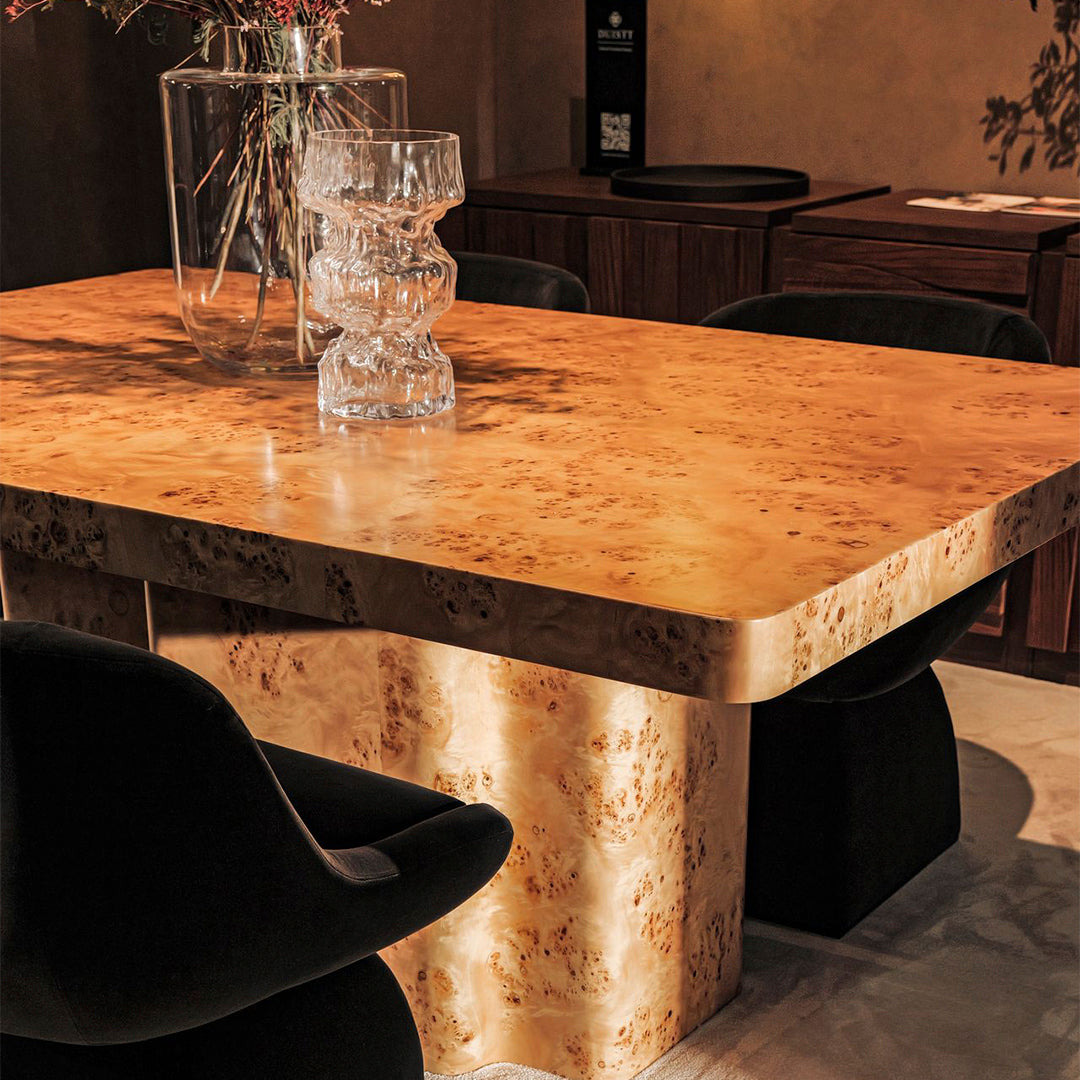 "Light brown burl wood table with a smooth finish and geometric pattern, set against a neutral backdrop."