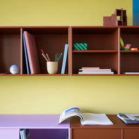 "Colorful bookshelf with earthy brown, pastel pink, green striped, and yellow accents creating a vibrant decor."