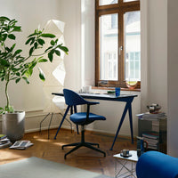 Blue chair and desk with geometric shapes, warm wooden accents, and a neutral rug in a bright, modern workspace.