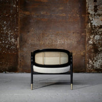 "Stylish black and cream chair featuring a woven pattern and gold accents, perfect for modern decor."
