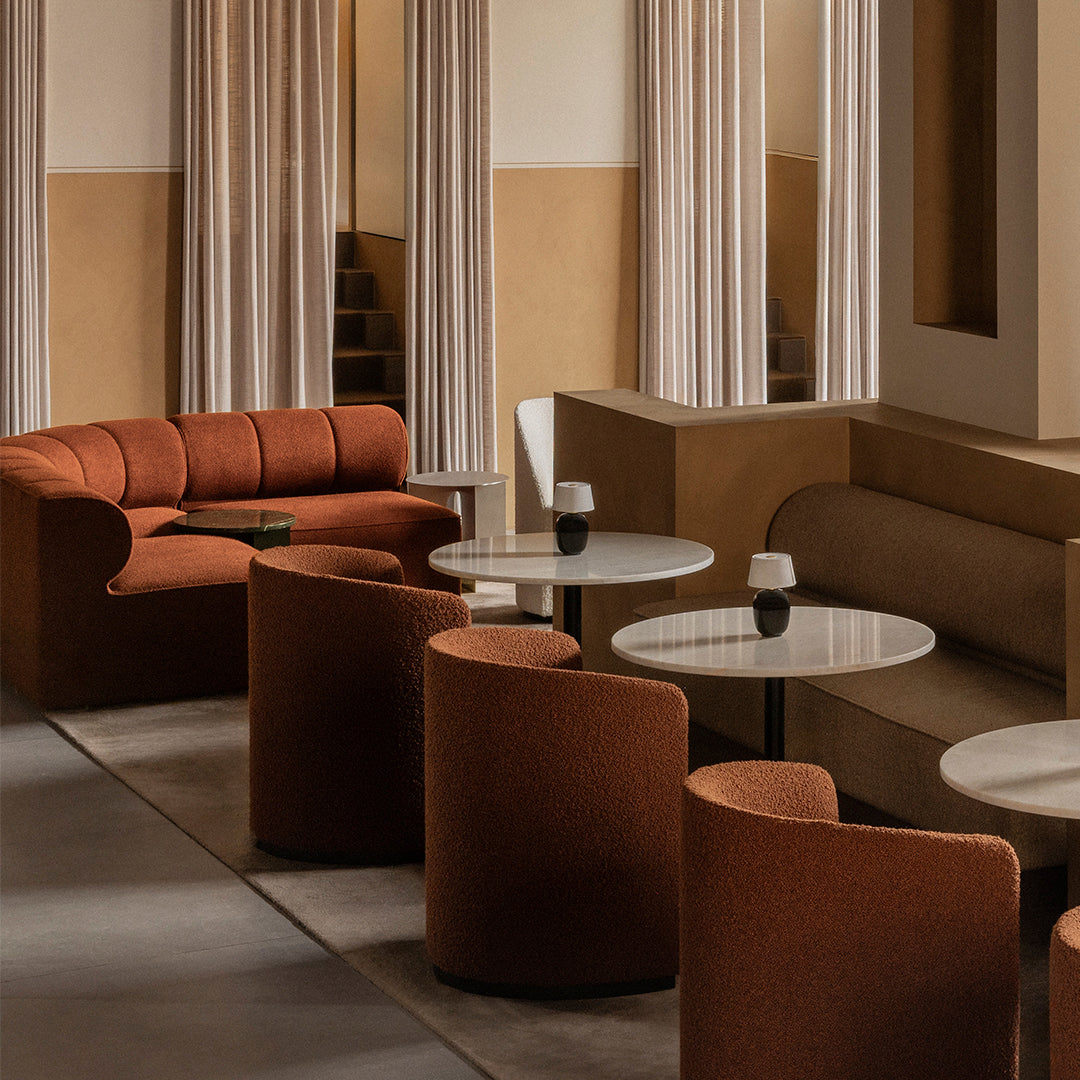 "Modern lounge with rich terracotta and neutral beige tones, featuring soft curves and elegant minimalist design."