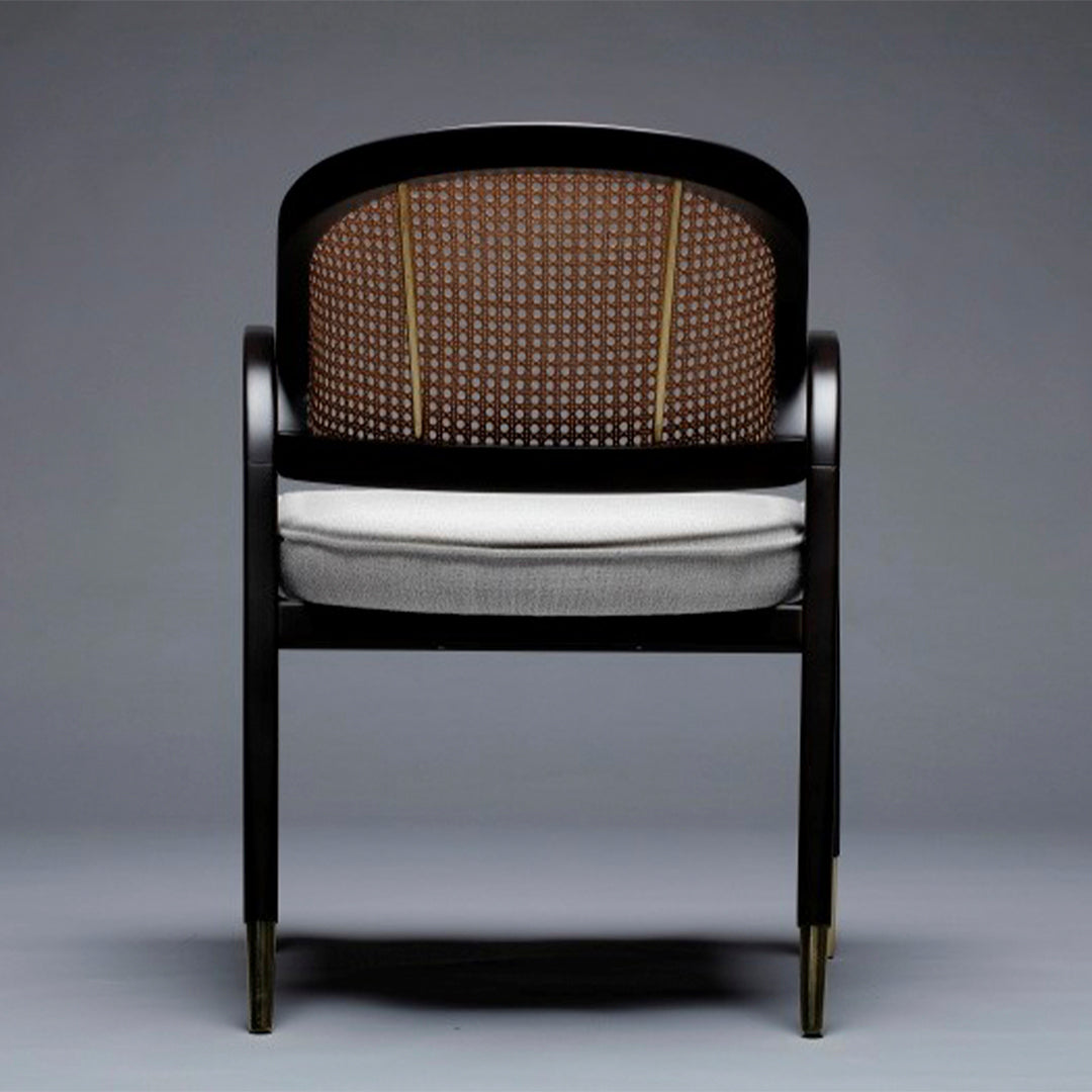 Elegant black wooden chair featuring a brown woven back and gray cushion with gold accents. Perfect for modern decor.