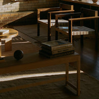 Wooden chairs with geometric patterns, warm earthy tones, and soft natural light. Cozy modern interior setting.