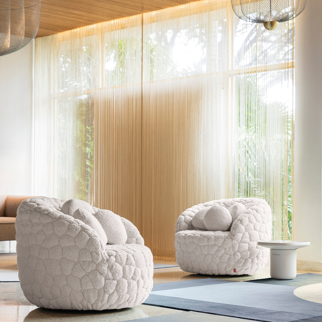 White, quilted bean bag chairs with a cozy texture, set against a soft blue rug and natural light backdrop.