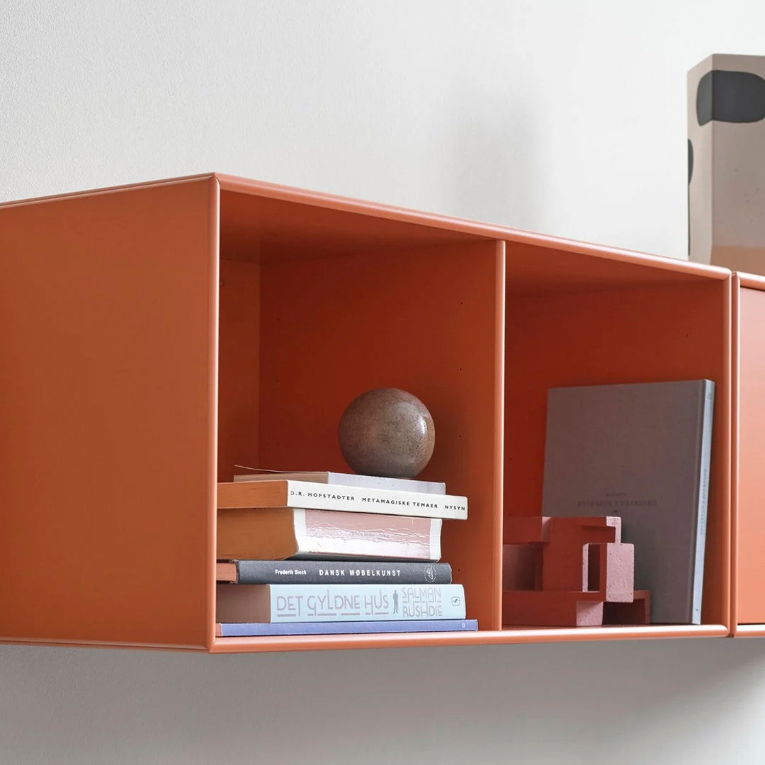 "Modern shelving unit in warm orange with geometric patterns, featuring books and decor in neutral tones."