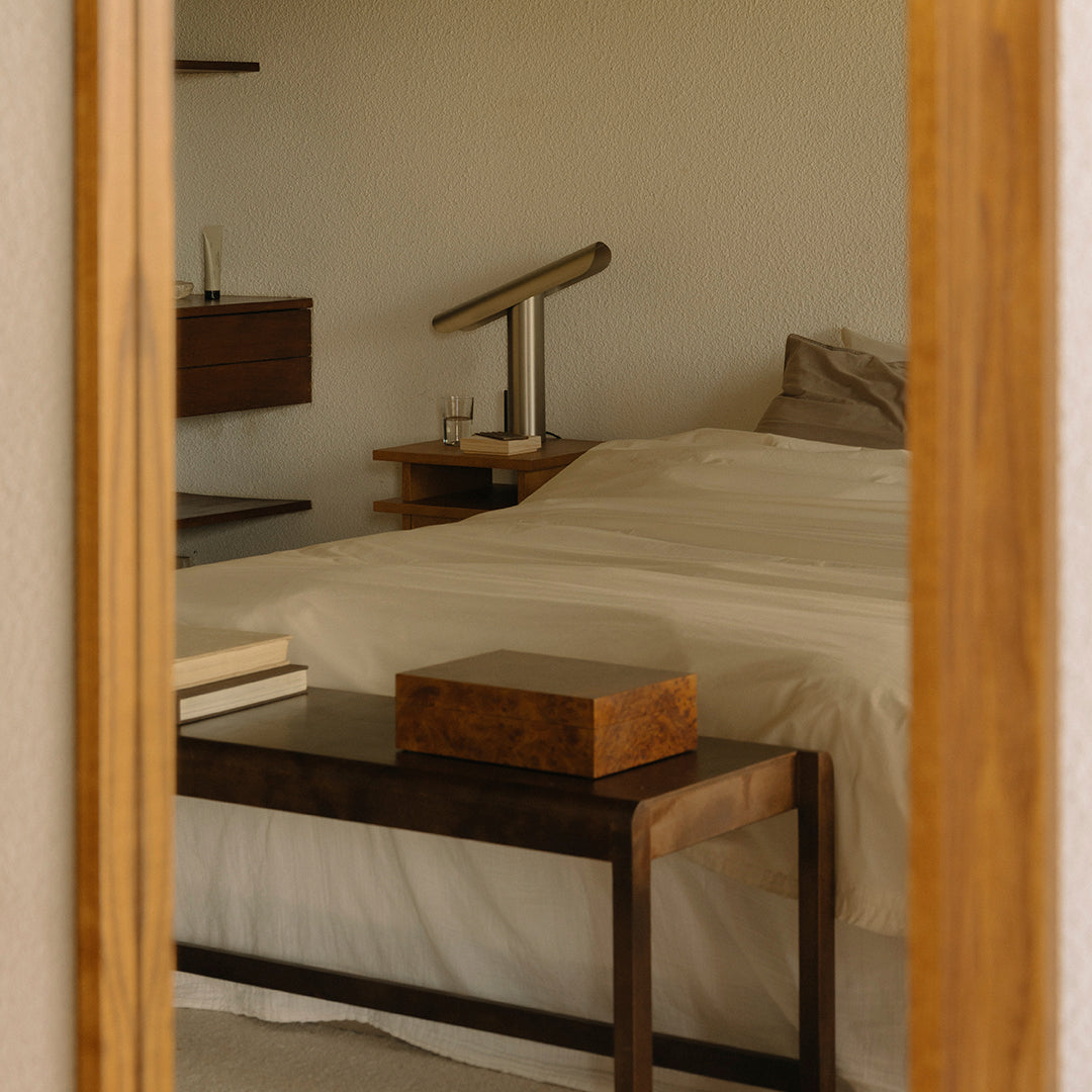 Elegant beige bedding with wooden furniture, creating a warm, cozy bedroom ambiance. Minimalist style with soft textures.