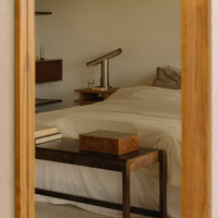 Elegant beige bedding with wooden furniture, creating a warm, cozy bedroom ambiance. Minimalist style with soft textures.