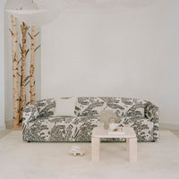 Black and white floral patterned sofa with a minimalist design, complemented by a light neutral carpet and decor.