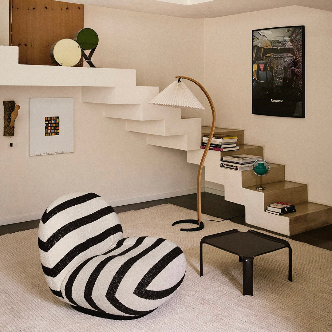 Black and white striped bean bag chair in modern indoor setting with minimalistic decor.