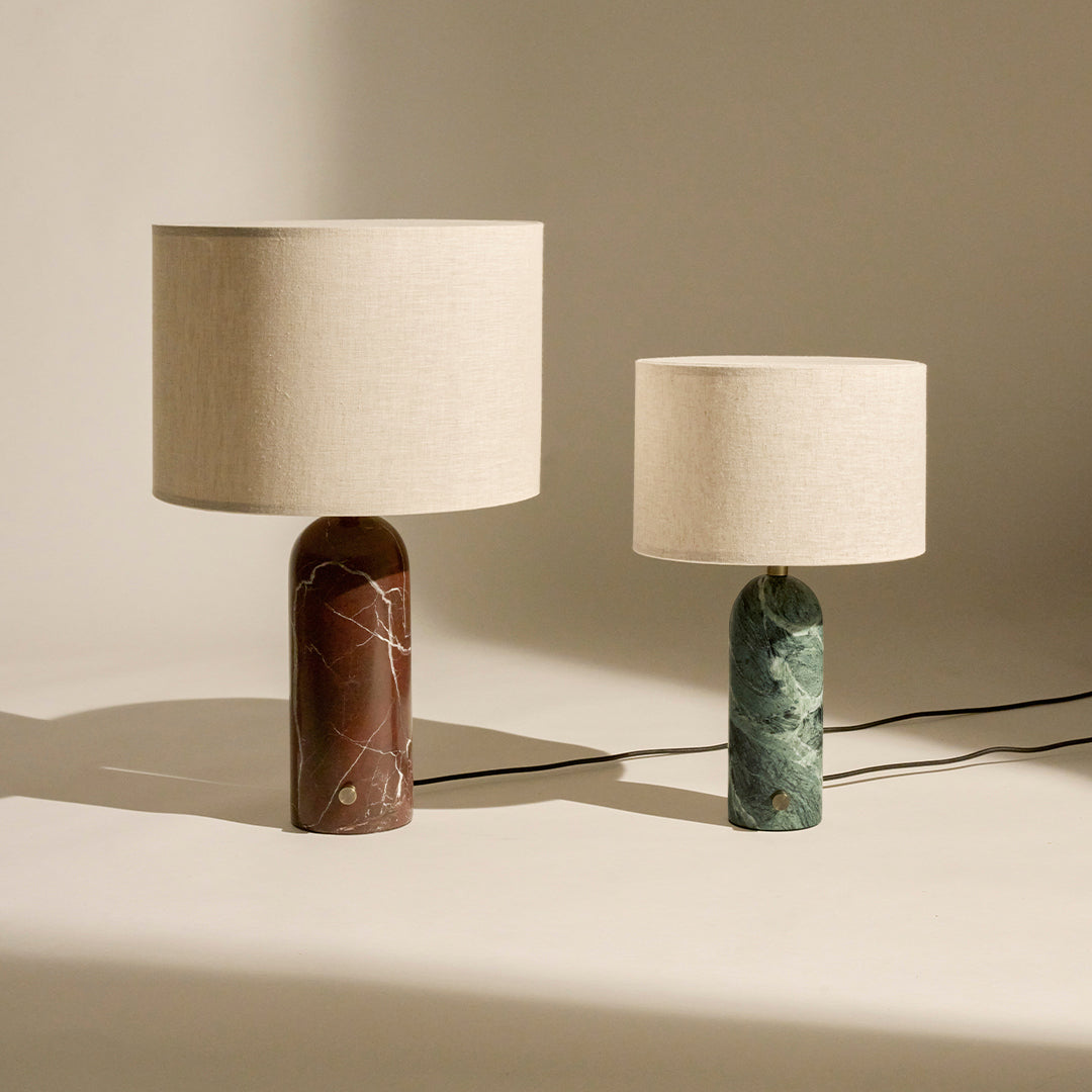 Two stylish lamps featuring a brown marbled base and a green marbled base, both with beige fabric shades.