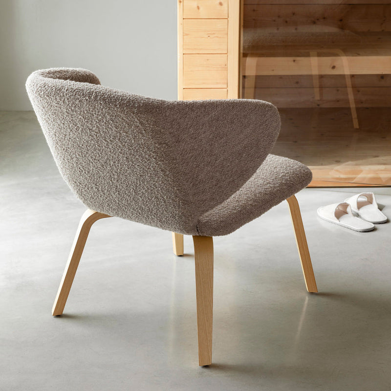 Modern light gray chair with soft, textured fabric and natural wood legs, perfect for contemporary decor.