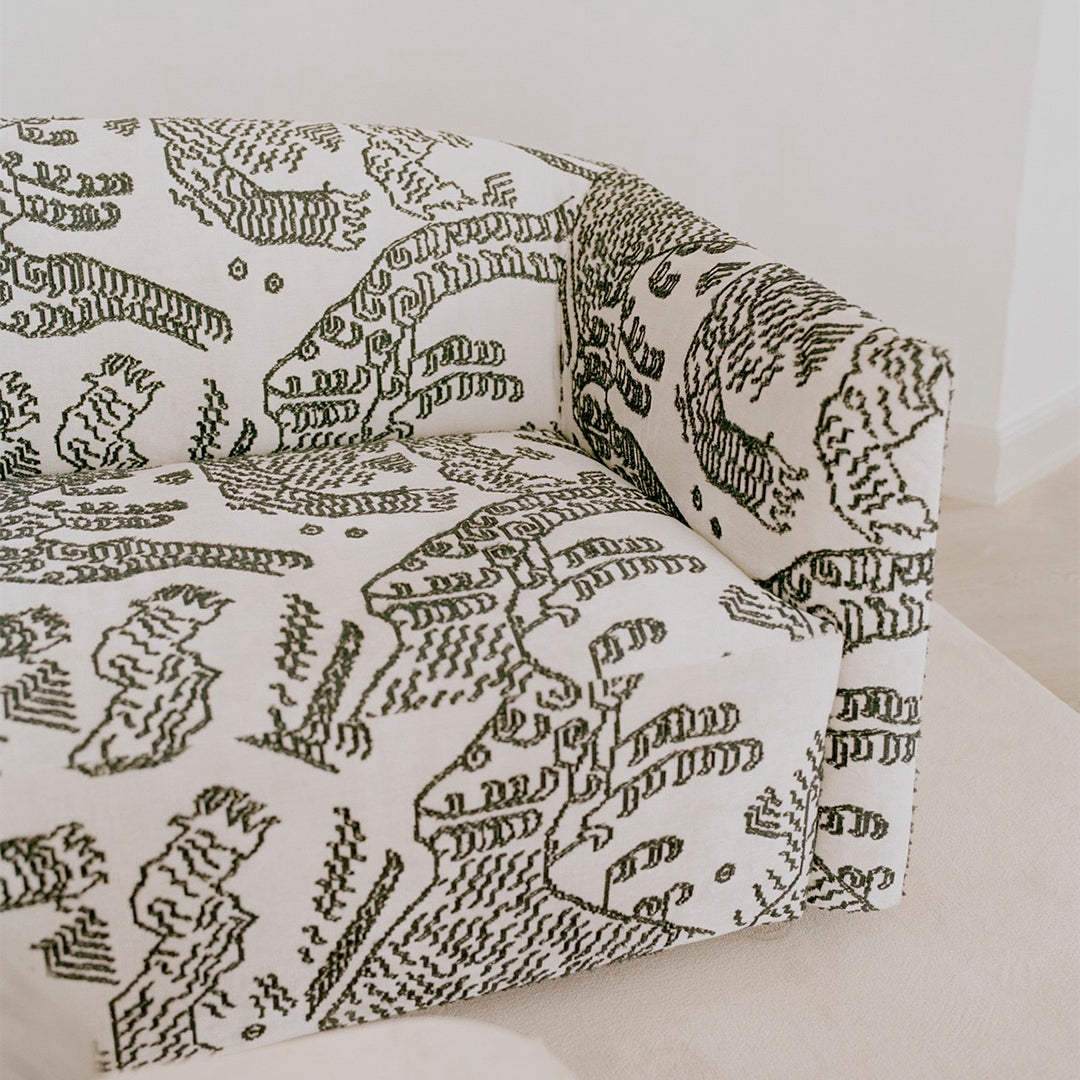 Green and white patterned sofa featuring abstract designs and organic shapes, perfect for modern decor.