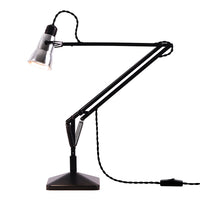 Modern black desk lamp with a sleek design and adjustable arms, featuring a silver shade and a textured cord.