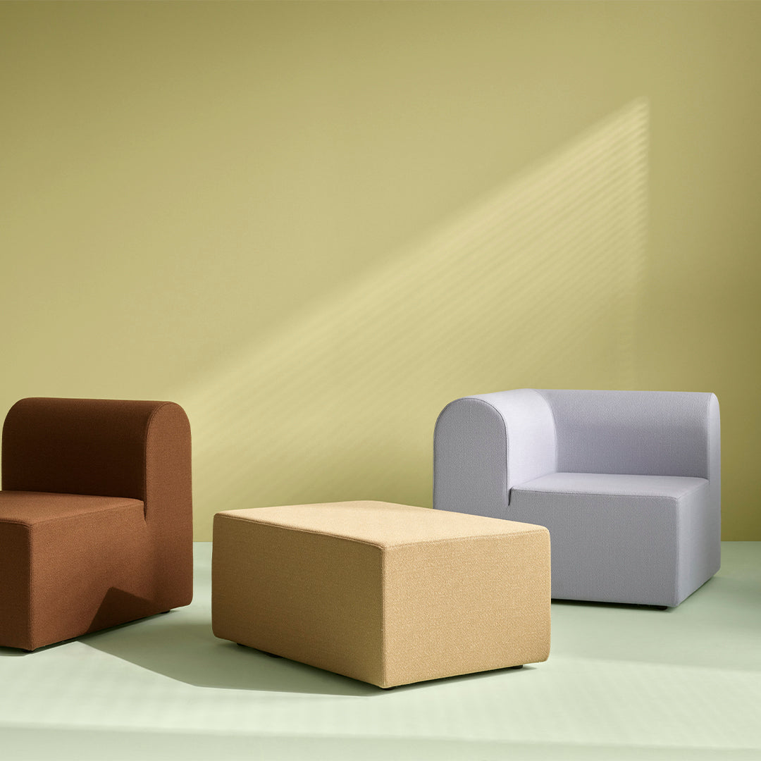 "Three modern furniture pieces in brown, light gray, and beige against a soft green and yellow backdrop."