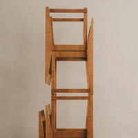 Stacked wooden chairs featuring a warm, natural oak finish with clean lines and minimalistic design.