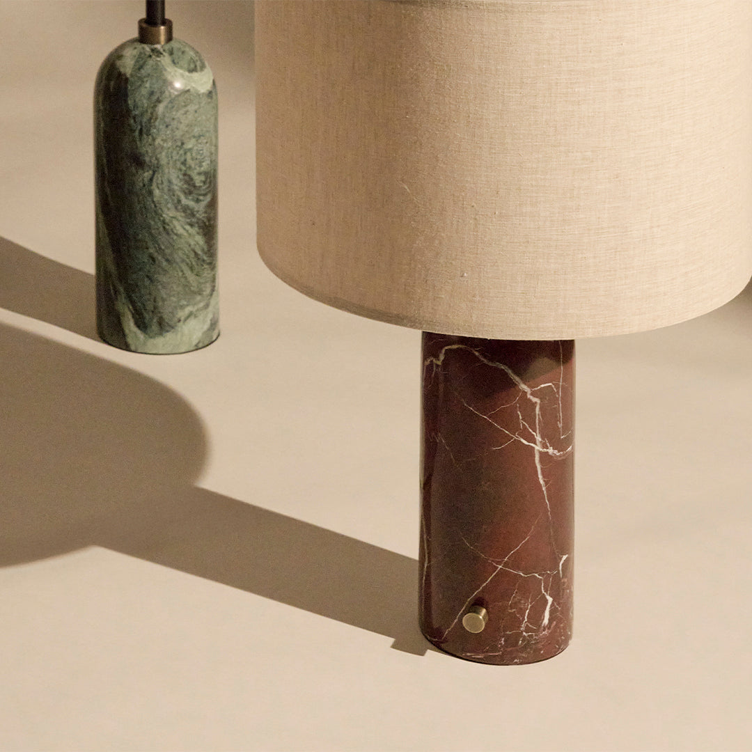 Brown marble lamp base with white veining, complemented by a beige fabric shade and a green marble accent.