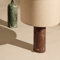 Brown marble lamp base with white veining, complemented by a beige fabric shade and a green marble accent.
