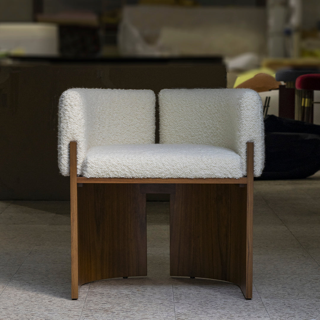 White upholstered chair with textured, fluffy surface and wooden base, featuring a minimalist design.