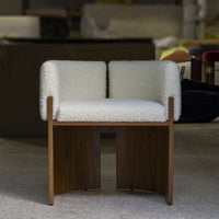 White upholstered chair with textured, fluffy surface and wooden base, featuring a minimalist design.