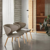 Neutral beige chairs with soft curves and light wooden legs, set against a modern, minimalist interior.
