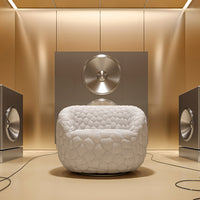 White quilted chair surrounded by metallic accents and a warm gold background, creating a modern, stylish look.